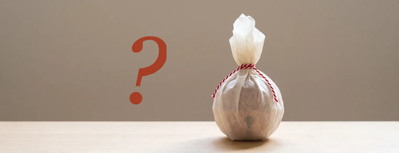 A small gift wrapped in washi paper, beside a question mark